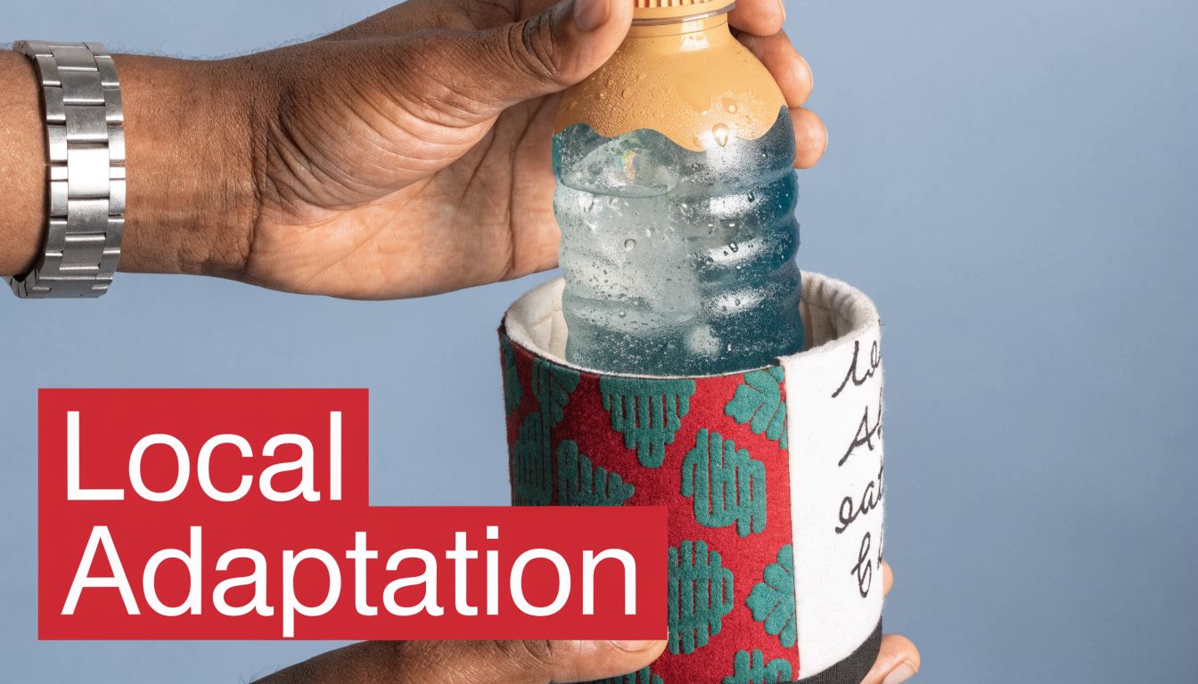 A person's hands placing a cold, sweating plastic bottle into a patterned, fabric drink cozy sleeve.