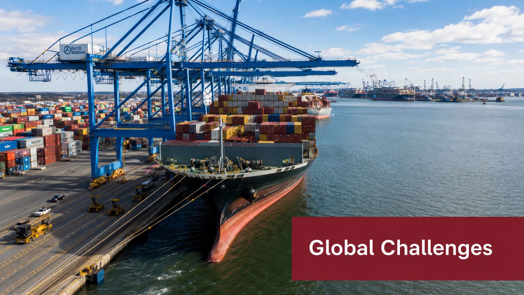 A large cargo ship docked at the Port of Baltimore under a clear blue sky.
